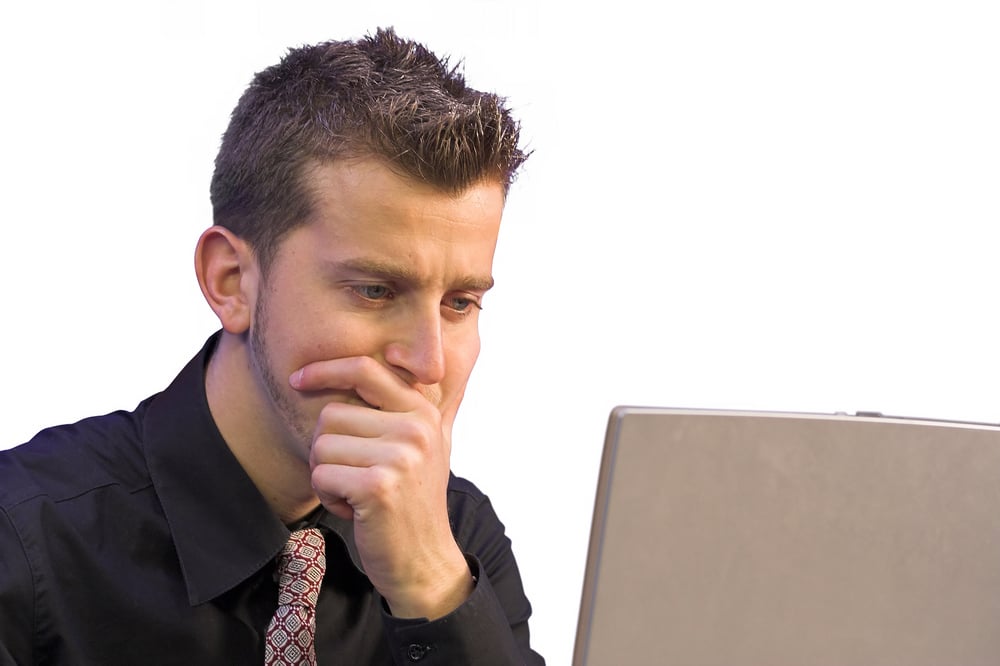 business man in front of a laptop very thoughtful-1